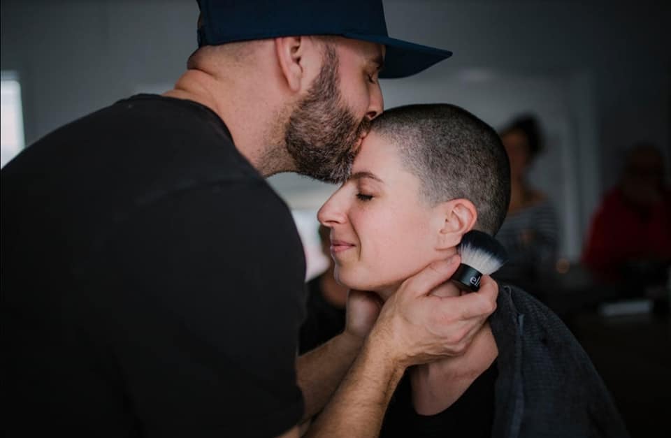 homme qui rase les cheveux de sa femme et lui donne un bec sur le front